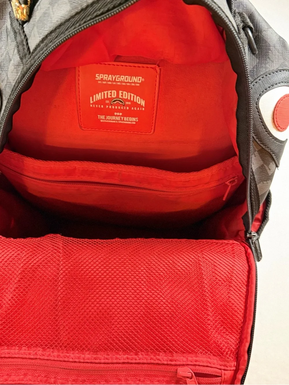 Sprayground Black Checkered Backpack with White and Red Shark Graphic